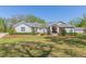 Charming one-story home with a lush green lawn, landscaped garden beds, and a welcoming entrance at 6644 Par Ct, Wesley Chapel, FL 33544
