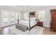 Spacious main bedroom with hardwood floors, tray ceilings, and access to a private outdoor area at 6644 Par Ct, Wesley Chapel, FL 33544