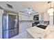 Well-lit kitchen featuring stainless appliances, pendant lighting, and tile flooring at 700 Starkey Rd # 514, Largo, FL 33771