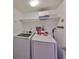 Efficient laundry room with washer, dryer, and overhead storage shelving at 700 Starkey Rd # 514, Largo, FL 33771