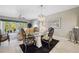 A dining room with stylish chairs, glass table and a view of a living room with a sliding glass door to balcony at 960 Starkey Rd # 5303, Largo, FL 33771