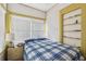 Bright bedroom featuring a comfortable bed, window with blinds, and a built-in shelving unit at 1004 E 22Nd Ave, Tampa, FL 33605