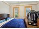 Bedroom featuring two windows with blinds, wood-look floors, and a clothes rack with apparel at 1004 E 22Nd Ave, Tampa, FL 33605