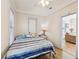 Bright bedroom with a striped bedspread, wood floors, and doorway to another room at 1004 E 22Nd Ave, Tampa, FL 33605