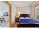 Bedroom with wood floors, bedside table, and doorway to kitchen, showcasing a bright and airy space at 1004 E 22Nd Ave, Tampa, FL 33605