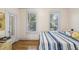 Inviting bedroom featuring wood-look floors, natural light from two windows, and neutral walls at 1004 E 22Nd Ave, Tampa, FL 33605