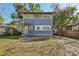 Two-story blue house with white trim, visible front porch, and surrounding trees in a yard at 1004 E 22Nd Ave, Tampa, FL 33605