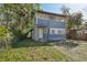 Two-story home with blue siding and white trim, complemented by lush greenery at 1004 E 22Nd Ave, Tampa, FL 33605