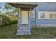 Quaint front porch with concrete steps, a white door, and a covered entrance at 1004 E 22Nd Ave, Tampa, FL 33605