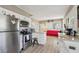 Kitchen and adjacent living area with stainless steel appliances, white cabinets, and hardwood floors at 1004 E 22Nd Ave, Tampa, FL 33605