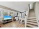 Bright and open-concept living room with hardwood floors, a kitchen view and a staircase at 1004 E 22Nd Ave, Tampa, FL 33605