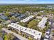Expansive aerial view of community featuring mature trees, several condo buildings and community pool at 11700 Park Blvd # 202, Seminole, FL 33772