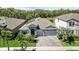 Aerial view of a well-maintained home with a three-car garage and landscaped yard in a suburban setting at 13227 Wildflower Meadow Dr, Riverview, FL 33579