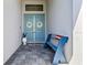 Charming front entrance featuring blue double doors with decorative wreaths, and an American flag bench at 13227 Wildflower Meadow Dr, Riverview, FL 33579