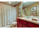 Bathroom featuring decorative seashell shower curtain, with red vanity and sink at 14813 Princewood Ln, Land O Lakes, FL 34638