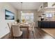 Well-lit dining room with modern decor, a view into the sunroom area, and black kitchen cabinets at 1515 Danbury Dr, Sun City Center, FL 33573