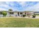 Charming single-story home with well-kept lawn, decorative bushes, and attached carport at 1515 Danbury Dr, Sun City Center, FL 33573
