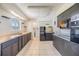 Spacious kitchen featuring dark cabinets, tile flooring, and view into the laundry room area at 1515 Danbury Dr, Sun City Center, FL 33573