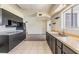 Bright kitchen featuring dark cabinets, a stainless steel sink, and tiled flooring at 1515 Danbury Dr, Sun City Center, FL 33573