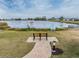 Scenic view of Swan Lake with a park bench and clear signage, inviting relaxation and nature observation at 1515 Danbury Dr, Sun City Center, FL 33573
