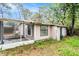 The backyard of the home featuring a screened-in porch, and green grass at 15165 Waverly St, Clearwater, FL 33760