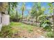 The backyard features a wooden fence with some small trees and vines at 15165 Waverly St, Clearwater, FL 33760