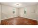 Empty bedroom showcasing wood-look flooring and natural light from two windows at 15165 Waverly St, Clearwater, FL 33760