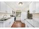 Updated kitchen features white cabinets, marble countertops, and stainless appliances at 15165 Waverly St, Clearwater, FL 33760