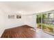 Living room with wood flooring, air conditioning, and sliding glass doors that lead to the backyard at 15165 Waverly St, Clearwater, FL 33760