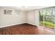 Living room with wood flooring, air conditioning, and sliding glass doors that lead to the backyard at 15165 Waverly St, Clearwater, FL 33760