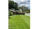Lush green backyard with mature trees and well-maintained lawn at 1567 Patton Dr, Dunedin, FL 34698