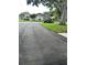 Wide paved driveway leading up to a home in a quiet neighborhood surrounded by mature trees at 1567 Patton Dr, Dunedin, FL 34698