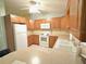 Traditional kitchen featuring wood cabinets, white appliances, and a double bowl sink at 1567 Patton Dr, Dunedin, FL 34698