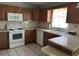 Traditional kitchen with wood cabinets, tile flooring, updated appliances, and plenty of counter space at 1567 Patton Dr, Dunedin, FL 34698