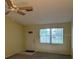 Cozy living room with neutral paint, a ceiling fan, and a window providing natural light at 1567 Patton Dr, Dunedin, FL 34698