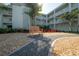 Exterior view of a community with a wooden bench, lush landscaping, and pathways at 1706 Belleair Forest Dr # 314, Belleair, FL 33756