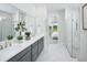 Luxurious bathroom with double vanity, marble shower, and a view into the main bedroom at 18264 Chromata Dr, Venice, FL 34293
