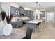 Inviting kitchen featuring gray cabinets, stainless steel appliances, an island with seating, and hardwood flooring at 18264 Chromata Dr, Venice, FL 34293