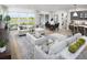 Bright living room with a large sliding glass door, a dining area, and a kitchen with bar seating at 18264 Chromata Dr, Venice, FL 34293
