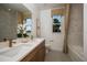 Well-lit bathroom featuring a tub/shower, double sinks, and wood cabinets offering a serene spa-like feel at 18604 Arbor Vista Dr, Venice, FL 34293