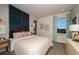 Well-lit bedroom featuring a padded blue headboard, window with curtains, and a cozy aesthetic at 18604 Arbor Vista Dr, Venice, FL 34293