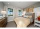 Bright bedroom featuring a bed, dresser, and windows offering a view of the green landscape at 18604 Arbor Vista Dr, Venice, FL 34293