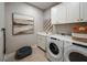 Neat laundry room features a washing machine, dryer, sink, and plenty of cabinet space for storage at 18604 Arbor Vista Dr, Venice, FL 34293