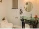 Stylish powder room with a unique glass vanity and oval mirror, complemented by modern fixtures and decor at 2308 W Jetton Ave, Tampa, FL 33629