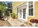 Charming yellow home featuring a brick path leading to an inviting entrance with white framed glass doors at 2308 W Jetton Ave, Tampa, FL 33629
