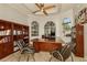 Home office features built-in bookshelves, a large desk, and elegant arched windows at 2308 W Jetton Ave, Tampa, FL 33629