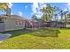 Expansive backyard featuring lush lawn, mature trees, and a screened-in patio at 2309 Valrico Forest Dr, Valrico, FL 33594