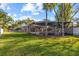 Expansive backyard featuring lush lawn, mature trees, and a screened-in patio at 2309 Valrico Forest Dr, Valrico, FL 33594