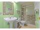 Charming bathroom with shell-framed mirror, pedestal sink, and walk-in shower for a spa-like experience at 2309 Valrico Forest Dr, Valrico, FL 33594