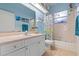 Bright bathroom featuring a vanity with gold fixtures, a tub, and an aquatic themed shower curtain at 2309 Valrico Forest Dr, Valrico, FL 33594